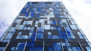 Tall glass tower with a blue grid facade