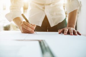 Person signing a document on a desk