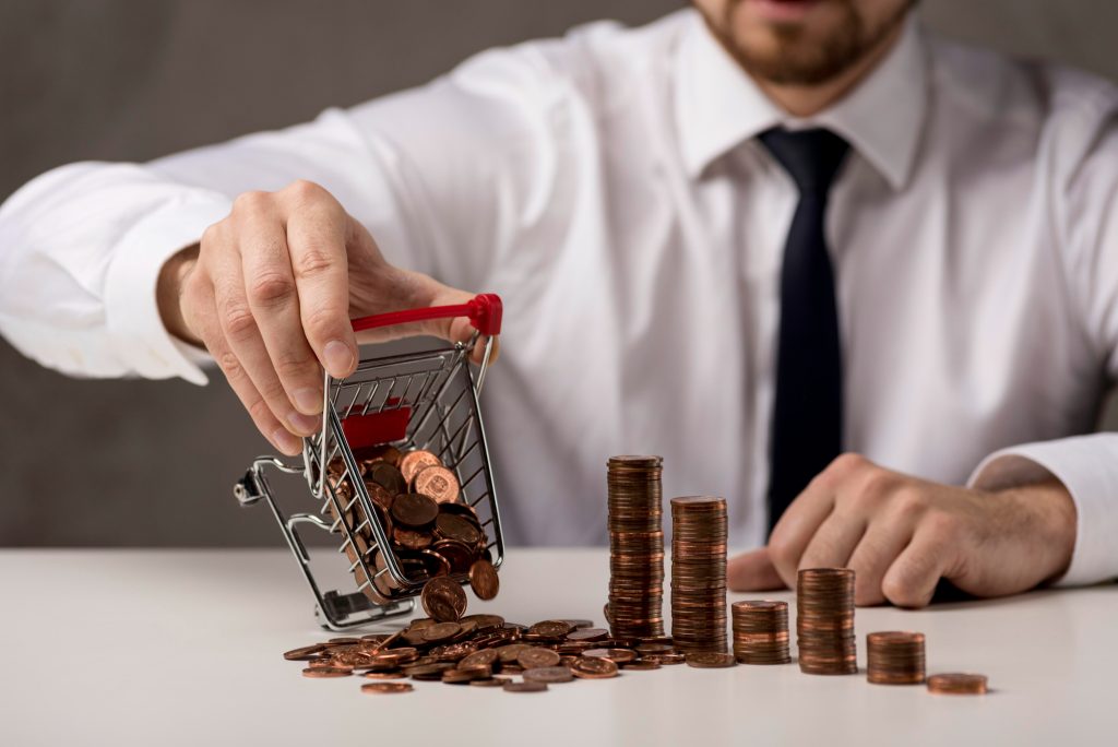 Office professional pushing a cart of coins representing equity capital and financial growth.